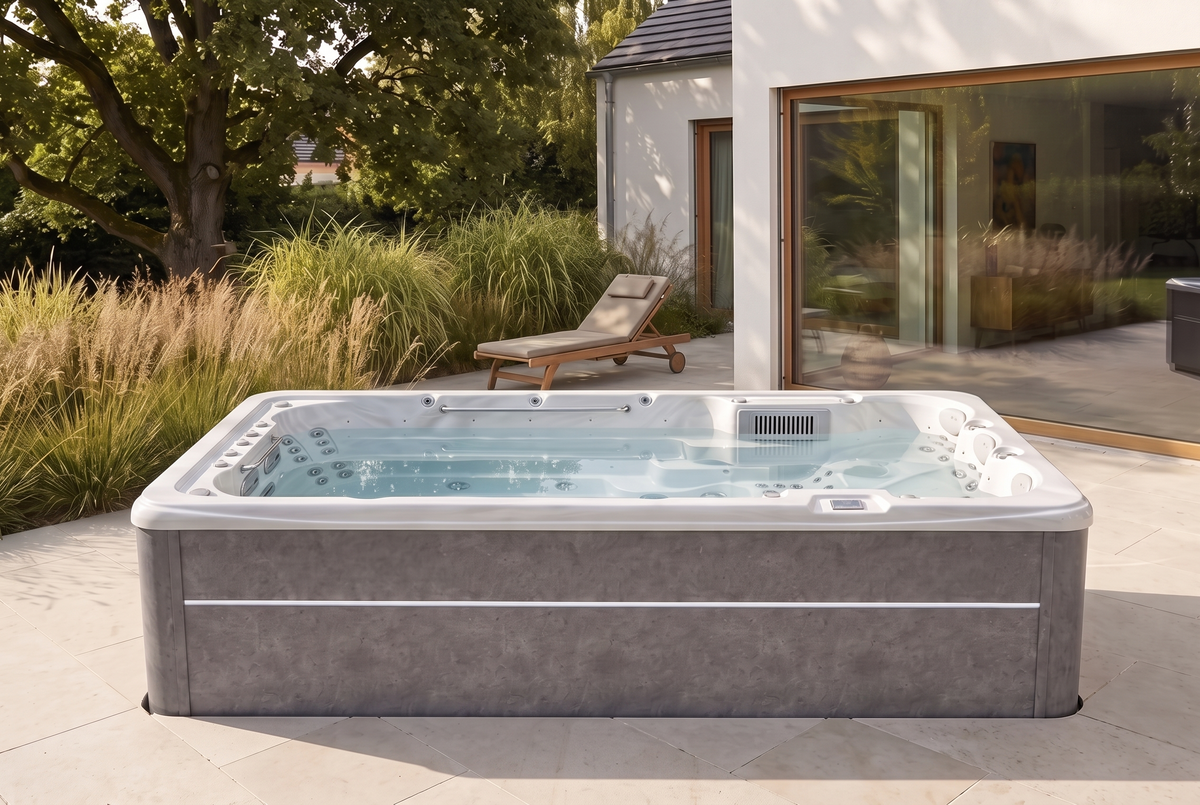 SwimFlow White intégré à une terrasse en pierre, devant une maison et un jardin paysager.